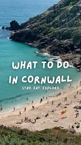 A high-angle, scenic landscape shot of a beach in Cornwall, used as a cover image for a travel listicle. The image features bright, natural daylight and clear, readable text overlay.
