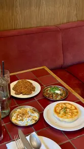 A short, polished montage showcasing the interior and various dishes at Nora, a Turkish restaurant in Canary Wharf. The video features slow, controlled pans of the dining area, close-ups of shared plates like hummus, courgette meatballs, grilled chicken, and octopus, as well as cocktails.