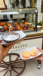 A short, handheld video showcasing a Fruttini pop-up cart located at The Chancery Rosewood, featuring close-ups of fruit-based desserts served in their shells.