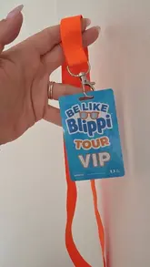 A simple, functional, and clear POV shot of a VIP lanyard for the 'Be Like Blippi' tour, effectively communicating the event and the 'VIP' experience for a family-oriented audience.