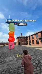 A bright, outdoor shot of a colourful, stacked-stone sculpture in Liverpool, used as an intro for a family day out itinerary.
