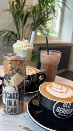 Visitors enjoying coffee at Old George Heritage cafe in Huddersfield, showcasing the cozy atmosphere.