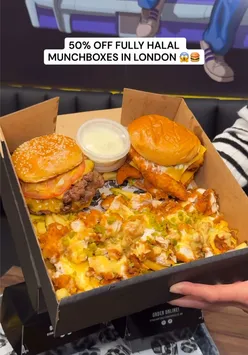 Excited diners enjoying loaded lunchboxes with burgers and fries at Straight Outta Nashville in Dalston, London.