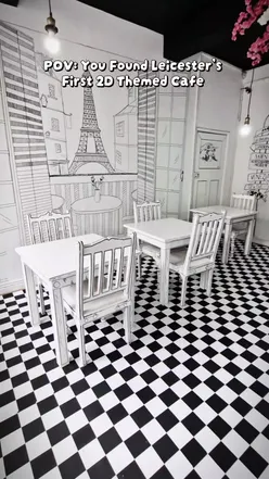 Interior of Tonalita café on Evington Road, featuring black and white comic-style decor and vibrant ube drinks.