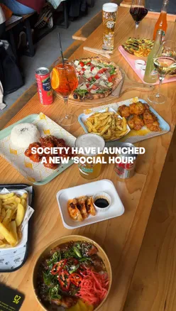 Guests enjoying Society's new social hour deals: main dishes for £10 and drinks for £5 in Manchester.