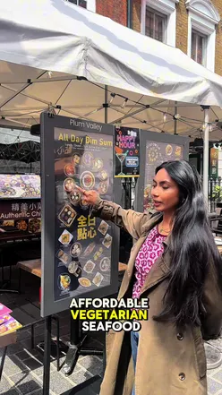 Enjoying delicious dishes in London's vibrant Chinatown despite mixed Google reviews.