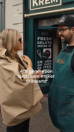 Ice cream lover enjoying a creamy cone at Krem Gelato, a historic shop in Westport, Mayo, famous for its unique flavors.