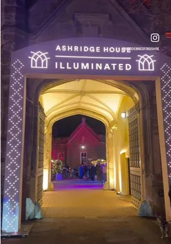 Visitors enjoying the Christmas light trail at Ashridge House, adorned with festive decorations and twinkling lights.