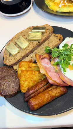 Irish breakfast featuring eggs, bacon, sausages, and toast at a Dublin eatery, showcasing local cuisine.
