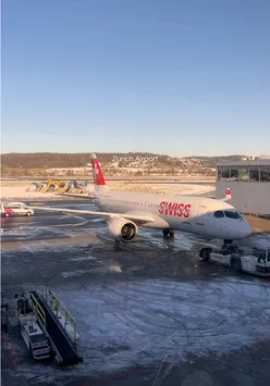 View of Zurich Airport with travelers and planes, showcasing vibrant airport vibes and busy terminal life.