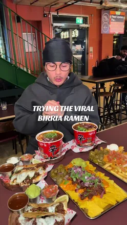 Person enjoying birria ramen at a restaurant in London, highlighting a unique dining experience.