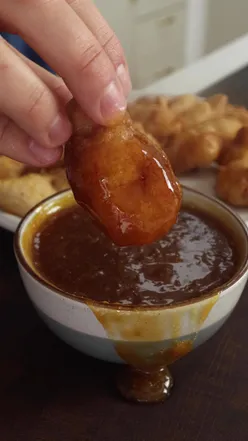 Delicious partridge nuggets served with a sweet and sour dip, featuring a crispy batter and vibrant flavors.