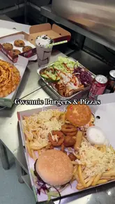 A review of a new takeaway venue in Tonypandy, showcasing their 'munch box' deal, pizza, kebab, milkshake, and cookies. The video follows the creator from the venue to home, highlighting the variety and portion sizes of the food.