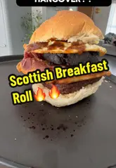 Hearty Scottish breakfast roll featuring fresh roll, bacon, fried egg, and black pudding, ideal for a hungover morning.