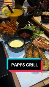A video review of Papi's Grill, an Afro-Fusion restaurant. The creator showcases various dishes including jollof rice, grilled fish, prawns, and suya, along with cocktails and dessert. The video highlights the restaurant's atmosphere, including a birthday celebration, and mentions their bottomless brunch offering.