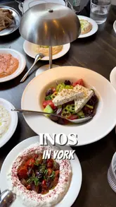 A vlog-style review of a Greek restaurant in York, featuring a group meal with family. The video showcases various dips, small plates, and grilled meats, highlighting the relaxed atmosphere and quality of the food.