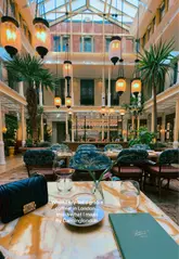 A short, aesthetic montage showcasing a luxurious London hotel tea room or cafe, focusing on the opulent interior design and the experience of having coffee and pancakes in a high-end setting.