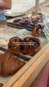 A short, aesthetic video showcasing a visit to August Bakery, featuring close-up shots of fresh bread, pastries, and an iced coffee. The video uses a handheld, vlog-style approach to capture the bakery's atmosphere and product range.