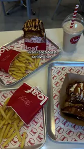 A short video showcasing the menu and food offerings at Loaf, featuring their viral French toast sandwiches, salted butter steak with chips, and buttermilk fried chicken. The video includes close-ups of the food and a shot of the menu board.