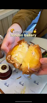 A short, energetic review of a London bakery, highlighting various pastries, quiches, and cakes. The video features the creator visiting the venue, showing the display, and tasting the food.
