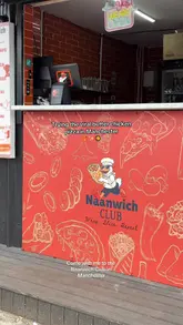 A short, fast-paced video showcasing the menu at Naanwich Club in Manchester, featuring close-ups of their naan wraps, samosas, and butter chicken pizza.