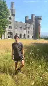A vlog-style tour of Penrhyn Castle in Wales, featuring the creator providing historical context about the castle's construction, its connection to the sugar trade, and a royal visit, while showcasing the architecture, interior rooms, and grounds.