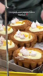 A short, fast-paced video showcasing a popular bakery in Liverpool called Pastille. The video highlights the queue, the variety of pastries available, and the creator's experience trying a lemon meringue croissant and a Spanish iced latte.